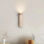 Minimalistyczna lampa ścienna z naturalnego kamienia emitująca ciepłe światło do salonu