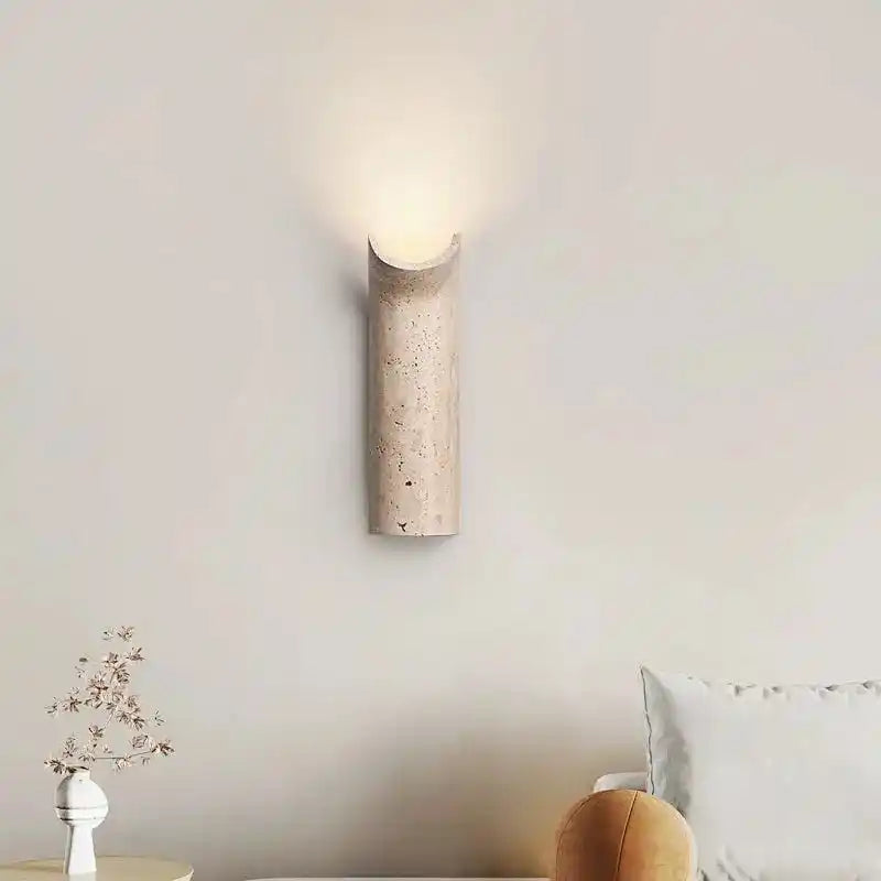 Minimalistyczna lampa ścienna z naturalnego kamienia emitująca ciepłe światło do salonu