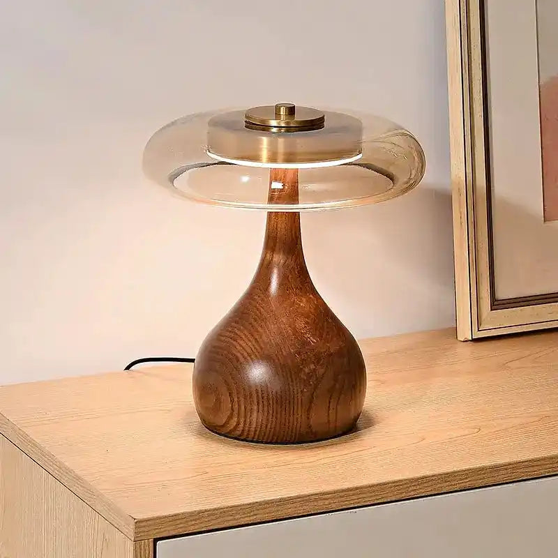 Elegancka lampy stołowe z drewnianą podstawą i przezroczystym szklanym kloszem na biurku