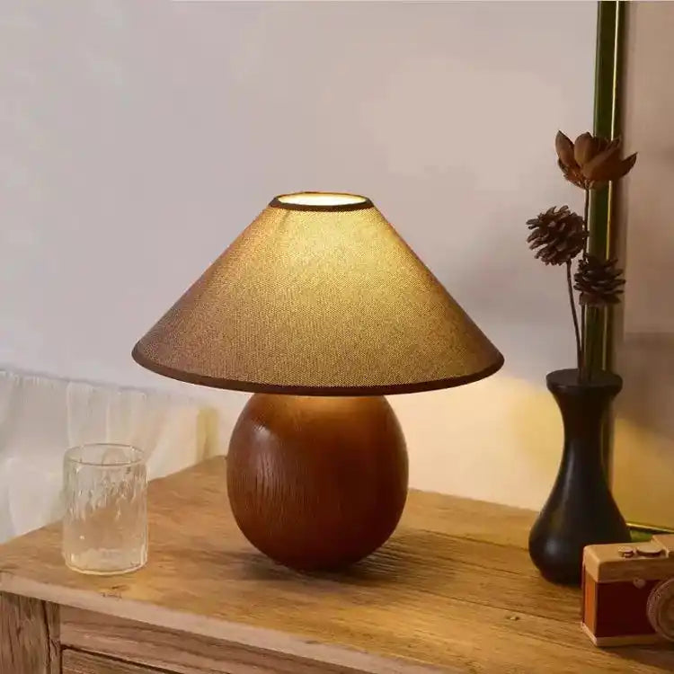 Lampy stołowe z drewnianą podstawą i stożkowym abażurem w ciepłym oświetleniu na drewnianym stole