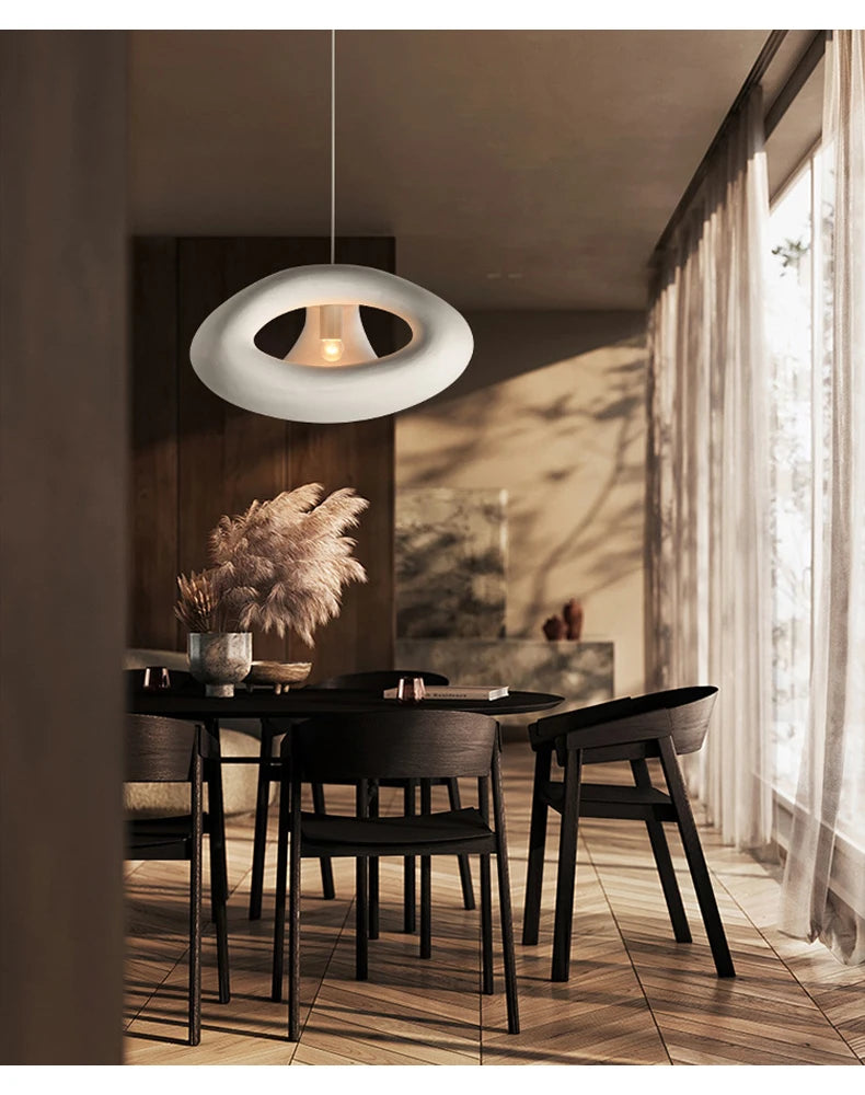 Nowoczesna lampa DRMIYA w stylu skandynawskim nad czarnym stołem i krzesłami w jadalni