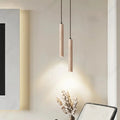Minimalistyczne lampy wiszące w kształcie długich walców z naturalnego materiału w nowoczesnym wnętrzu