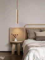 Lampy wiszące o minimalistycznym designie nad stolikiem przy łóżku w sypialni