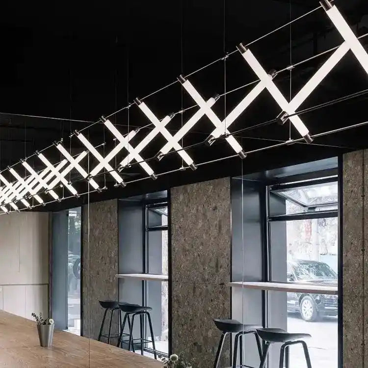 Nowoczesne lampy wiszące z geometrycznym wzorem oświetlające przestrzeń przy oknach