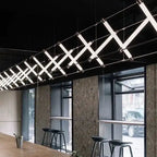 Nowoczesne lampy wiszące z geometrycznym wzorem oświetlające przestrzeń przy oknach