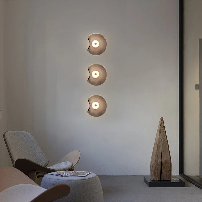 Nowoczesny plafon abay w formie trzech okrągłych lamp ściennych ustawionych pionowo w salonie minimalistycznym
