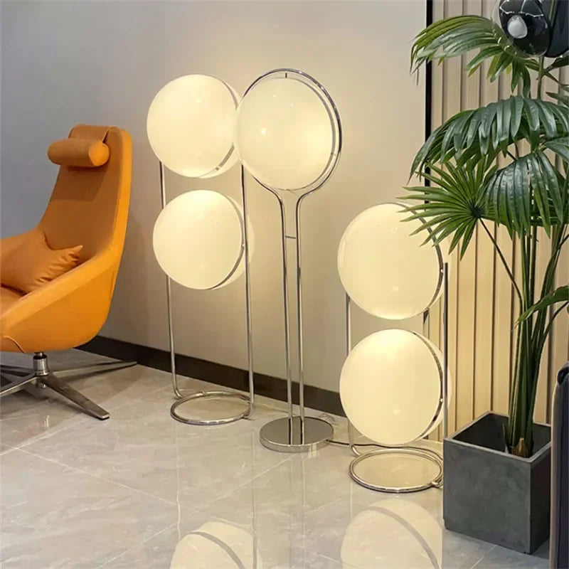 Nowoczesna lampa podłogowa, wykonana z metalu i szkła, z okrągłymi kloszami, idealna do salonu