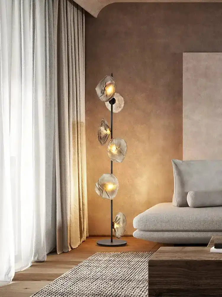 Nowoczesna lampa stojąca z pięcioma źródłami światła w eleganckim salonie z szarą sofą