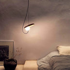 Nowoczesna lampa wisząca z okrągłą żarówką w minimalistycznym wnętrzu sypialni