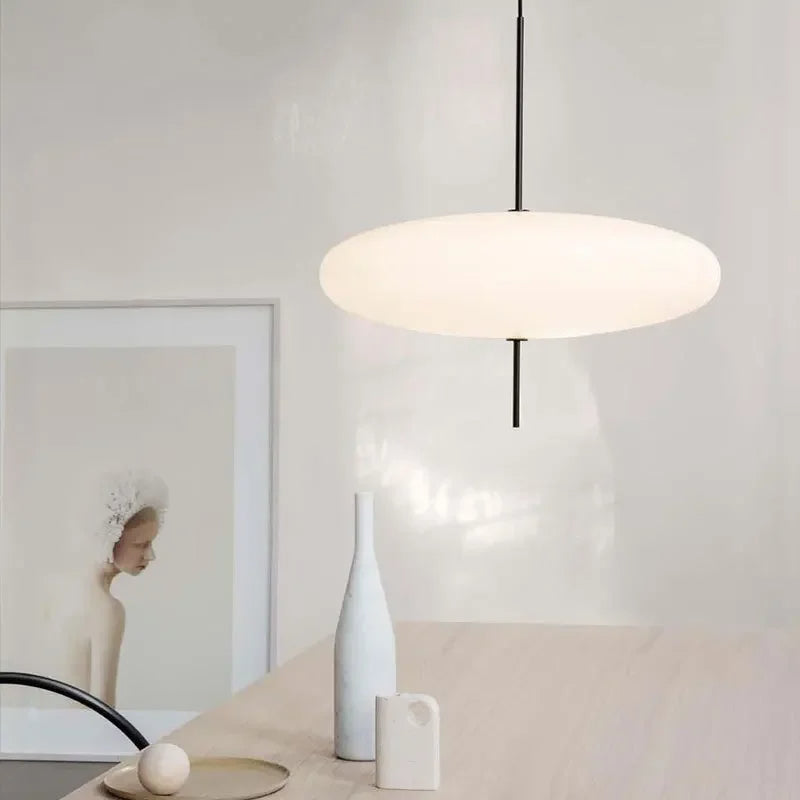 Nowoczesne lampy wiszące JIANKEXING o minimalistycznym designie nad jasnym stołem z dekoracjami