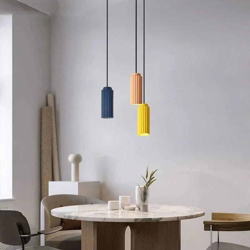 Nowoczesne lampy wiszące JOYINLED w trzech kolorach nad marmurowym stołem w jadalni