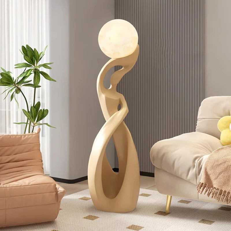 Gbbmade rzeźbiarska lampa stojąca w kształcie abstrakcyjnej postaci z kulistym źródłem światła