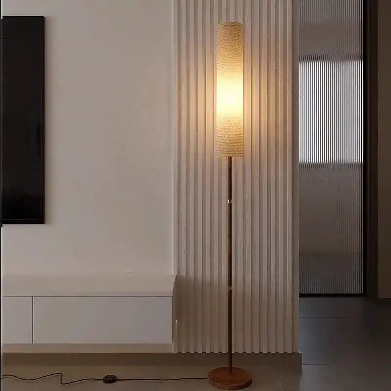 Stylowa lampa do wnętrz stojąca z podłużnym jasnym abażurem na drewnianej podstawie