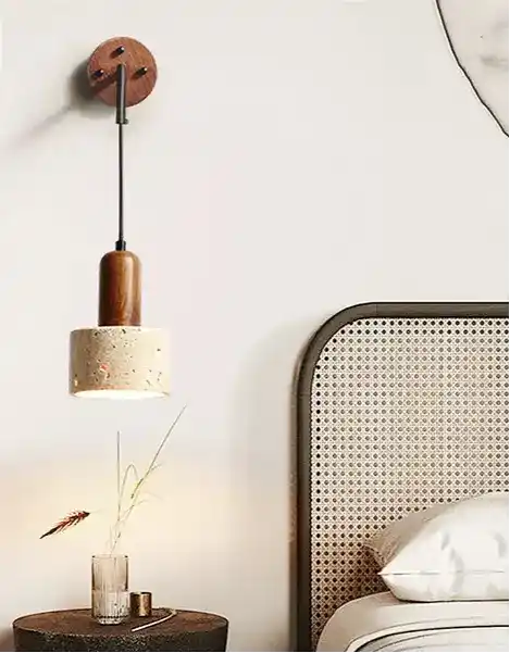 Stylowa lampa wisząca z drewnianym i betonowym kloszem nad stolikiem nocnym obok łóżka