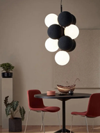 Nowoczesny żyrandol JIN YI Lighting Store z kulistymi czarnymi i białymi kloszami nad stołem
